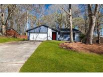 Charming single-story home with a well-maintained front yard and an attached two-car garage at 7256 Attache Way, Riverdale, GA 30296