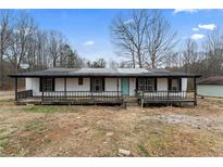 Ranch-style home with a covered front porch and mature trees in a rural setting at 9132 Brewer Rd, Villa Rica, GA 30180