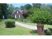 Charming two-story brick home with lush green lawn and long driveway at 3620 Highpoint Rd, Cumming, GA 30041