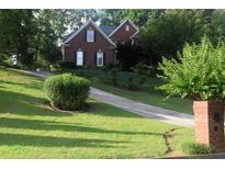 Charming two-story brick home with a well-manicured lawn and a long driveway at 3620 Highpoint Rd, Cumming, GA 30041