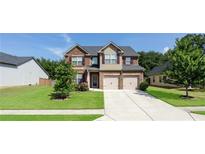 Beautiful brick two-story home with a two-car garage and a well-manicured lawn at 207 Birchwood Dr, Loganville, GA 30052