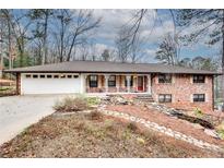 Charming brick home featuring a well-maintained yard, a two-car garage, and inviting front porch at 2722 Oswood Dr, Tucker, GA 30084