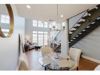 Open-concept living room with hardwood floors, a modern chandelier, and a staircase at 1253 Caroline Ne St, Atlanta, GA 30307