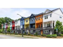 View of colorful townhomes with individual front porches and manicured landscaping at 2036 Bixby Byway Se Dr, Atlanta, GA 30317