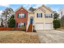 Charming two-story home with a combination brick and siding exterior, set against a backdrop of mature trees at 3519 Cast Palm Dr, Buford, GA 30519