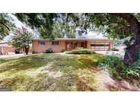 Charming brick home with a well-maintained lawn and mature trees at 961 Kingston Nw Rd, Conyers, GA 30012