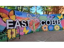 Colorful 'East Cobb' mural on a brick wall featuring butterflies, flowers, and a heart artwork at 5816 Riverstone Cir # 11, Atlanta, GA 30339