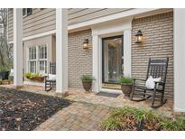 Charming brick home featuring a cozy front porch with rocking chairs and inviting curb appeal at 2528 Fernleaf Nw Ct, Atlanta, GA 30318