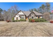 Charming home featuring stone and stucco exterior accents, beautiful landscaping, and a welcoming front entrance at 30 Magnolia Dr, Oxford, GA 30054