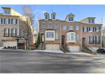 Brick townhomes with detailed trim, dormers and individual garages create appealing street view at 538 Sarabrook Ne Pl, Atlanta, GA 30342