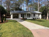 Charming home featuring a brick-lined driveway, well-manicured lawn, and a covered carport at 2466 Sharondale Ne Dr, Atlanta, GA 30305