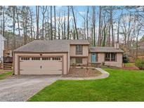 Charming single-Gathering home featuring a spacious front yard and a two-car garage at 9480 Hillside Dr, Roswell, GA 30076