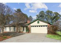 Charming single-story home featuring a brick chimney, attached garage, and a well-maintained front yard at 541 Buckingham Cir, Marietta, GA 30066