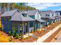 Charming row of modern homes with gray exteriors, metal roofs and landscaped yards at 155 Mado Ln, Palmetto, GA 30268