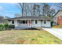Charming single-story home with a cozy front porch and red front door at 1830 Jan Hill Ne Ln, Atlanta, GA 30329
