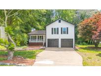 Inviting home with a two-car garage, covered front porch, and lush landscaping at 101 Summer Pond Trl, Lawrenceville, GA 30046