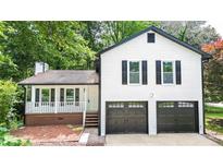 Charming two-story home boasts a welcoming front porch and a convenient two-car garage at 101 Summer Pond Trl, Lawrenceville, GA 30046