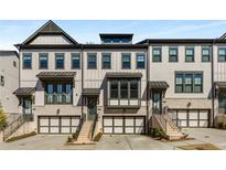 Charming townhome showcasing a brick and siding facade, complemented by a one-car garage and inviting entryway stairs at 2353 Medlock Ln, Decatur, GA 30033