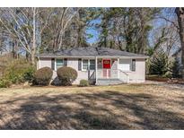 Charming single-story home with a red door, a landscaped yard, and traditional curb appeal at 1743 Thomas Ter, Decatur, GA 30032