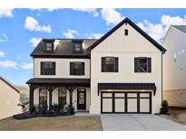 Charming two-story home with a brick facade, black shutters, and a two-car garage, offering timeless curb appeal at 1590 Branthaven Ln, Auburn, GA 30011