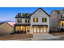 Charming two-story home features a modern white exterior with black accents and a well-manicured lawn at 1590 Branthaven Ln, Auburn, GA 30011