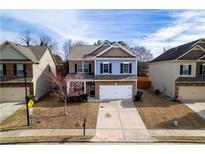 Charming two-story home featuring a well-maintained front yard and attached two-car garage at 1390 Napa Valley Sw Dr, Lawrenceville, GA 30045