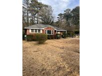 Charming brick home with a cozy front yard and mature trees, offering a serene suburban setting at 4300 Shady Lane Way, Forest Park, GA 30297