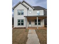 Charming two-story white home featuring a covered front porch and newly installed sod at 5115 N Pratt St, Covington, GA 30014