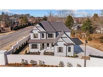 Stunning new construction home featuring a light gray facade, dark shutters and roof, and a landscaped front yard at 2711 Twisted Oak Ne Ln, Marietta, GA 30066