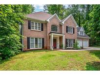 Charming two-story brick home with a manicured lawn and mature trees at 5485 Brookstone Nw Dr, Acworth, GA 30101