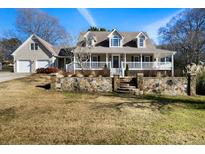 Inviting two-story home with stone accents, a covered porch, and a two-car garage enhancing curb appeal at 110 North Ave, Hiram, GA 30141