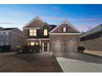 Charming brick home with two-car garage and manicured lawn at dusk at 2045 Broadmoor Way, Fairburn, GA 30213