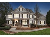 Stunning two-story home with neutral siding, dark shutters, and a welcoming front porch with a swing at 4113 Gold Mill Rdg, Canton, GA 30114
