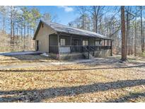 Inviting single-story home with a cozy porch and a well-maintained yard surrounded by mature trees at 93 Mill Creek Rd, Hiram, GA 30141