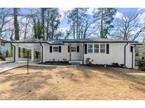 Charming single-story home with a white brick facade and a covered carport, creating an inviting curb appeal at 1937 Joseph Ct, Decatur, GA 30032