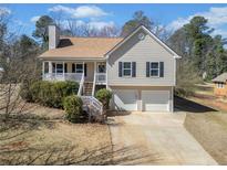 Charming two-story home with a welcoming front porch and attached two-car garage at 303 Wood Wind Dr, Woodstock, GA 30189