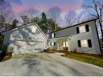 Charming two-story home with white siding, black shutters, and attached garage offers curb appeal at 152 Weatherstone Pkwy, Marietta, GA 30068