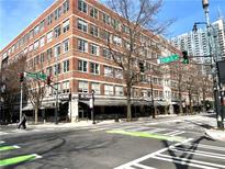 Street view of brick building with shops and restaurants, featuring sidewalks and crosswalks at 800 Peachtree Ne St # 8415, Atlanta, GA 30308