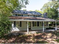 Two-story home featuring a covered porch with white pillars and a black front door at 724 Se Cowan Se Rd, Conyers, GA 30094