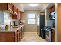 A view of the kitchen, featuring wood cabinets, light countertops, and stainless steel appliances at 795 Hammond Dr # 1812, Atlanta, GA 30328