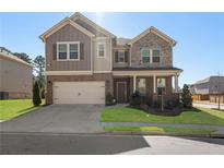 Charming two-story home with brick and stone accents, a two-car garage, and a well-manicured front lawn at 3218 Hidden Valley Cir, Lawrenceville, GA 30044