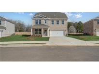 Charming two-story home with a light brick facade, well-manicured lawn, and a spacious two-car garage at 116 Dalston Cv, Stockbridge, GA 30281