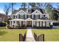 Charming two-story home with gray siding, black shutters, inviting front porch, and lush green lawn at 2190 Rugby Ave, Atlanta, GA 30337