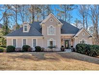 Charming home featuring a stone facade, arched windows, mature trees and a well manicured lawn at 4990 Sawgrass Nw Pl, Acworth, GA 30102