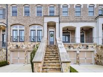 Charming brick townhome featuring stone accents, a private entrance, and an attached one-car garage at 5006 Merton Ln, Marietta, GA 30068