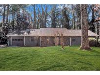 Charming single-story home with a stone accent front and a well-manicured lawn at 6865 Timberclair Ct, Lithonia, GA 30058