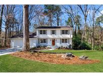 Charming white two-story home with attached garage and well-manicured lawn at 2818 Thornbriar Rd, Atlanta, GA 30340