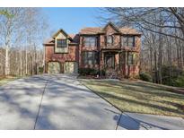 Two-story brick home featuring an attached two-car garage and a well-maintained lawn at 2782 Blue Moon Dr, Buford, GA 30519