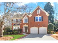 Charming two-story brick home featuring an attached two car garage and manicured landscaping at 420 Glenridge Close Ct, Atlanta, GA 30328