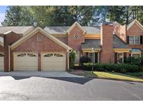 Charming brick townhome with a two-car garage and manicured landscaping at 52 Ivy Chase Ne, Atlanta, GA 30342
